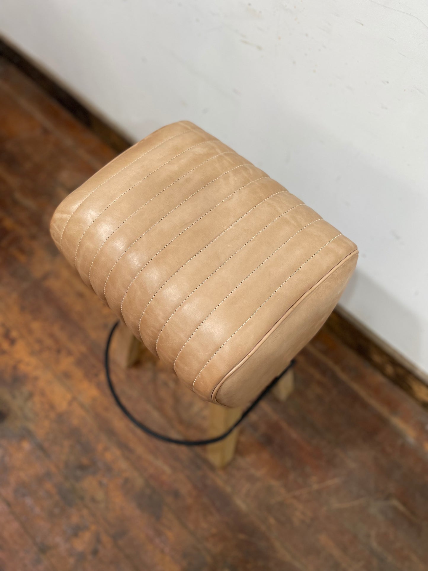 Pommel stool with light tan leather seat