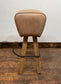 Pommel stool with light tan leather seat
