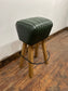 Pommel stool with green leather seat