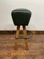Pommel stool with green leather seat