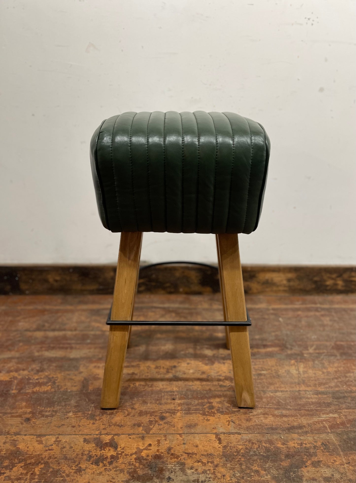 Pommel stool with green leather seat