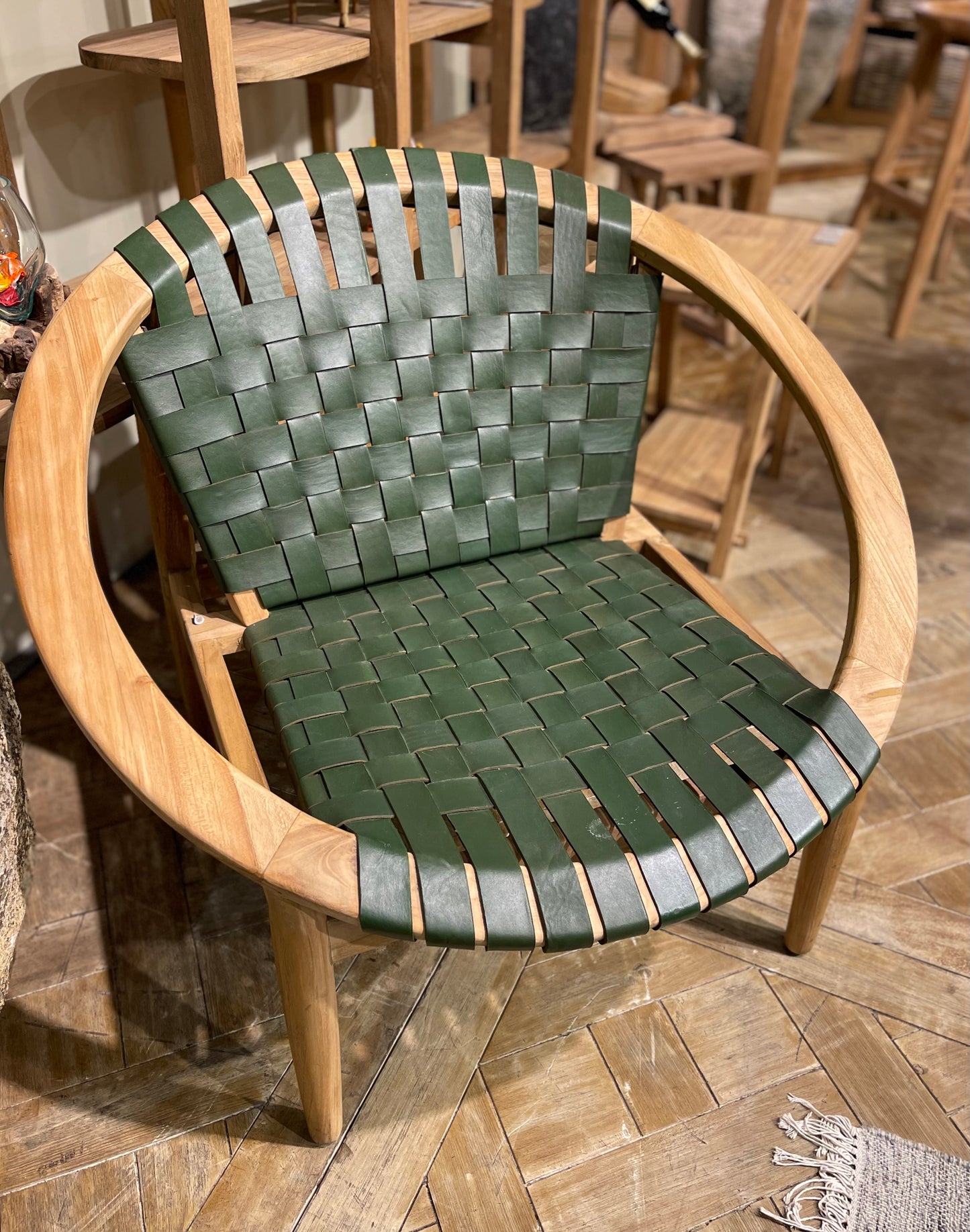 Stylish moon chair with wooden frame and green leather seat
