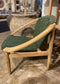 Stylish moon chair with wooden frame and green leather seat