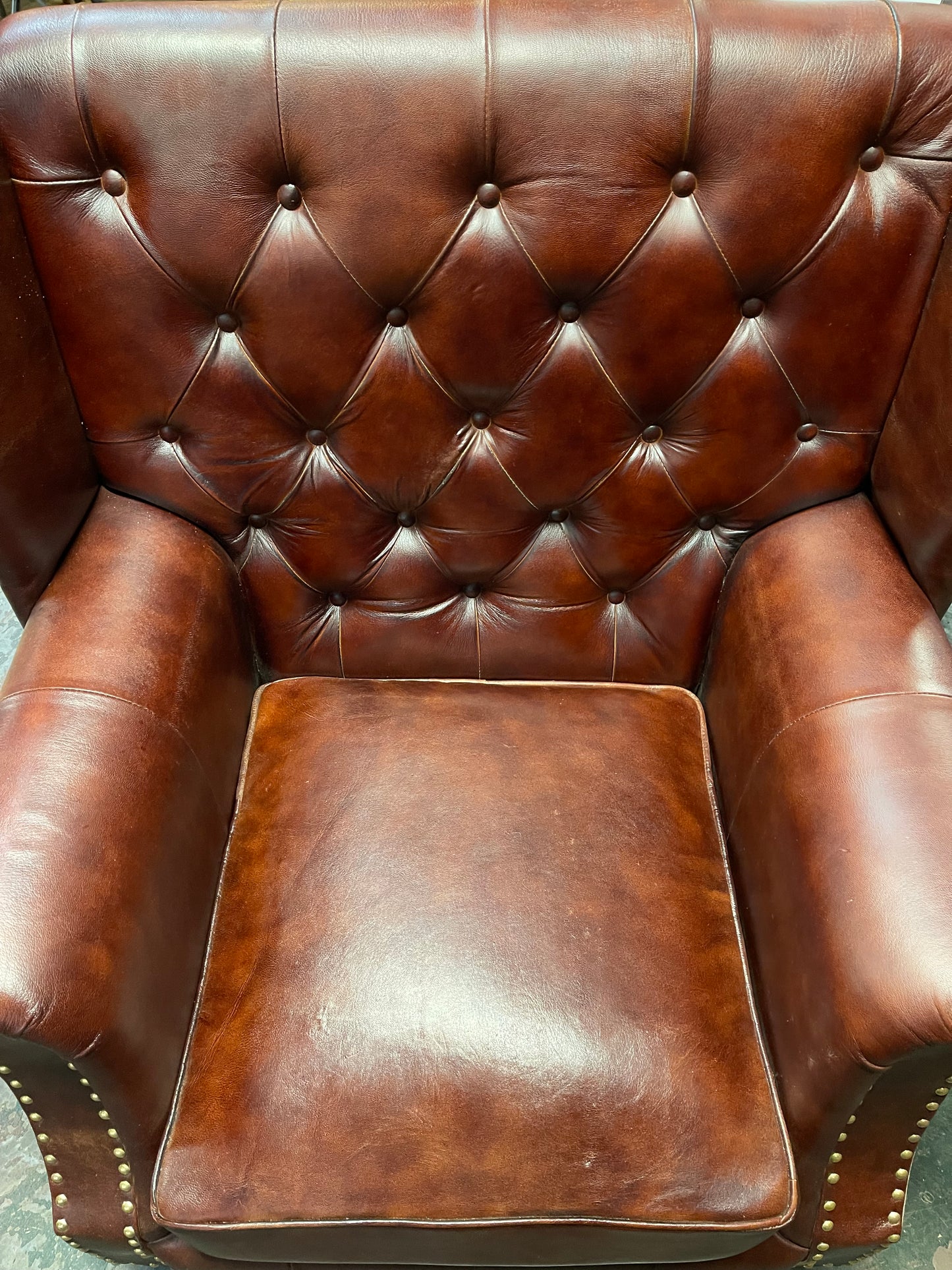 Chestnut brown leather armchair with button back