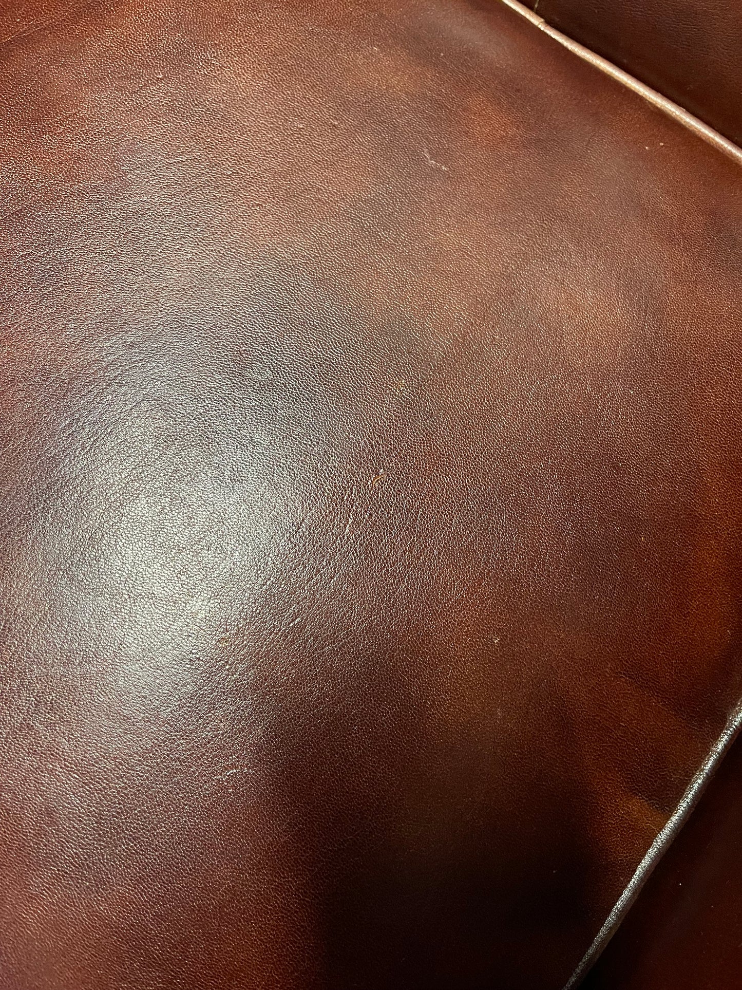 Chestnut brown leather armchair with button back