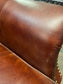 Chestnut brown leather armchair with button back