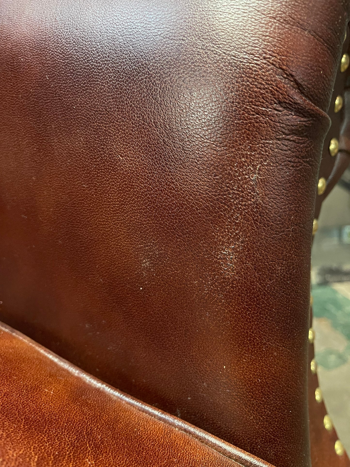 Chestnut brown leather armchair with button back