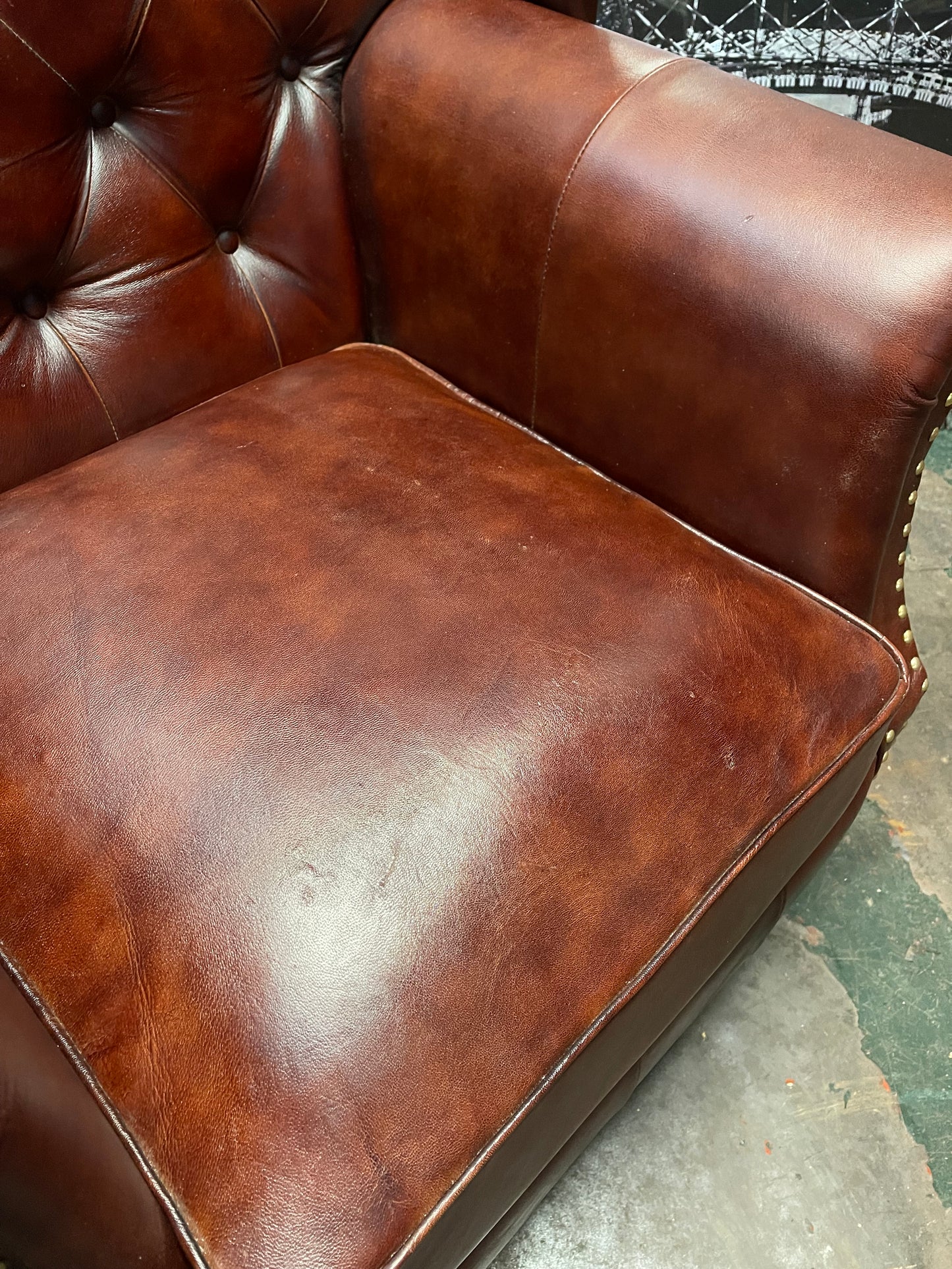 Chestnut brown leather armchair with button back